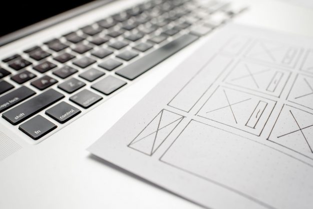 UX website designer drawing wireframe sketch of prototype, frame